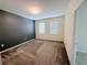 Carpeted bedroom with two windows, light walls, and a dark accent wall at 1308 Shinnecock Hills Dr, Davenport, FL 33896