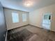 Carpeted bedroom with two windows, light walls, and a dark accent wall at 1308 Shinnecock Hills Dr, Davenport, FL 33896