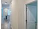 Hallway with wood-look flooring leading to a kitchen with a waterfall countertop peninsula at 1308 Shinnecock Hills Dr, Davenport, FL 33896