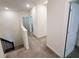 Upstairs hallway features neutral carpeting and bright white walls leading to bedrooms and bathrooms at 1308 Shinnecock Hills Dr, Davenport, FL 33896