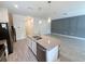 Well-lit kitchen showcasing an island with a stainless steel sink, black appliances, and tiled flooring at 1308 Shinnecock Hills Dr, Davenport, FL 33896