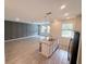 Open-concept living area with kitchen island, tile flooring, and plenty of natural light at 1308 Shinnecock Hills Dr, Davenport, FL 33896