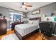 Bedroom featuring wood floors, ceiling fan, a dresser and an upholstered bed at 16 Sawfish Ct, Kissimmee, FL 34759