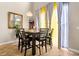 Dining room with a dark wood table, dark upholstered chairs, large window with yellow/blue curtains and tall ceilings at 16 Sawfish Ct, Kissimmee, FL 34759