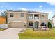 Inviting two-story home featuring a well-manicured lawn, garden, and solar panels, creating an appealing curb presence at 16 Sawfish Ct, Kissimmee, FL 34759