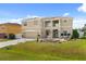 Two-story home with a large front yard, fountain, two-car garage, and solar panels on the roof at 16 Sawfish Ct, Kissimmee, FL 34759