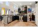 Bright kitchen featuring stainless steel appliances, dark cabinets, and natural stone countertops and backsplash at 16 Sawfish Ct, Kissimmee, FL 34759
