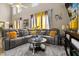Spacious living room featuring a large gray leather sofa, yellow decorative pillows, and a corner television at 16 Sawfish Ct, Kissimmee, FL 34759