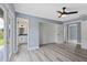 Bedroom with ceiling fan, wood-look floors, access to the backyard and a view into the bathroom at 17 S Flag Ct, Kissimmee, FL 34759