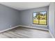 Bright bedroom featuring wood-look floors and a large window with a view of the outdoors at 17 S Flag Ct, Kissimmee, FL 34759