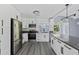 Modern kitchen with stainless steel appliances, white cabinets, black hardware, and an open concept to the dining room at 17 S Flag Ct, Kissimmee, FL 34759