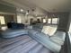 Spacious living room features a large sectional couch and an open floor plan into the kitchen, with light gray wood floors at 17 S Flag Ct, Kissimmee, FL 34759