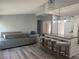 Modern living room with gray walls, wood floors, and an open kitchen layout with an island and bar stools at 17 S Flag Ct, Kissimmee, FL 34759