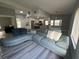 Bright living room with a large gray sectional, gray wood floors, and an open floor plan into the newly renovated kitchen at 17 S Flag Ct, Kissimmee, FL 34759