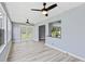Bright sunroom featuring gray wood floors, neutral paint, recessed lighting, and a view into the kitchen with a pass-through at 17 S Flag Ct, Kissimmee, FL 34759