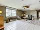 Comfortable living room featuring neutral walls, a ceiling fan, and ample natural light from a large window at 171 Stanley Bell Dr, Mount Dora, FL 32757