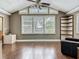 Living room with vaulted ceiling, hardwood floors, plantation shutters, and open to another seating area, with a ceiling fan at 171 Stanley Bell Dr, Mount Dora, FL 32757