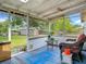 Enclosed porch with a wicker chair, a small table, and views of the backyard and shed at 171 Stanley Bell Dr, Mount Dora, FL 32757