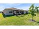 Expansive green backyard featuring a covered patio area for comfortable outdoor living and entertaining at 17335 Million Lakes Ct, Clermont, FL 34714
