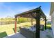 Inviting backyard patio with pergola, comfortable seating, and picturesque landscaping, ideal for outdoor gatherings at 17335 Million Lakes Ct, Clermont, FL 34714