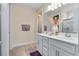 Bright bathroom features a double sink vanity with sleek countertops and a large mirror at 17335 Million Lakes Ct, Clermont, FL 34714