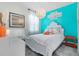 Vibrant bedroom with a white bed, accent wall, and colorful décor at 17335 Million Lakes Ct, Clermont, FL 34714