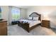 Comfortable bedroom with a classic wooden bed, carpet, and view to the back yard at 17335 Million Lakes Ct, Clermont, FL 34714
