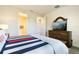 Bedroom features a striped bedspread, carpet, and a wooden dresser with a mounted TV at 17335 Million Lakes Ct, Clermont, FL 34714