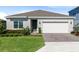 Charming single-story home featuring a manicured lawn, neutral paint, and a two-car garage at 17335 Million Lakes Ct, Clermont, FL 34714