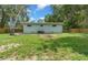 Large backyard with lush green grass, mature trees, and a cozy, private outdoor space at 1881 Cottonwood St, Orange City, FL 32763