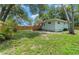 Serene backyard featuring a well-kept lawn, wooden fence, and mature trees for added privacy at 1881 Cottonwood St, Orange City, FL 32763
