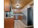 Practical kitchen with stainless steel appliances, wood cabinets, granite counters, and plank flooring at 1881 Cottonwood St, Orange City, FL 32763