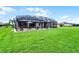 Expansive backyard with manicured lawn, screened patio, and beautiful landscaping at 2260 Grayling St, Orlando, FL 32820