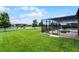 Backyard with a screened patio, putting green, and lush green lawn extending to the lake at 2260 Grayling St, Orlando, FL 32820