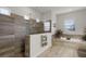 Elegant bathroom features a glass shower, a soaking tub, and decorative wood-style tiling at 2260 Grayling St, Orlando, FL 32820