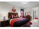 A stylish bedroom with decor, featuring a bed with red and black bedding and wall art at 2260 Grayling St, Orlando, FL 32820
