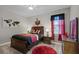 Inviting bedroom with red and black accents, a window bringing in natural light, and comfortable furnishings at 2260 Grayling St, Orlando, FL 32820