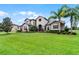Elegant home with lush green lawn and mature palm trees, offering curb appeal and a welcoming feel at 2260 Grayling St, Orlando, FL 32820