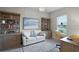 Bright office with wooden floors, complemented by stylish furniture and shelves filled with books and decorative objects at 2260 Grayling St, Orlando, FL 32820