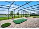 Spacious screened-in patio features a putting green and outdoor seating, perfect for entertaining at 2260 Grayling St, Orlando, FL 32820