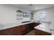 Granite countertop wet bar featuring glass shelving, wine cooler, sink, and cabinetry at 2260 Grayling St, Orlando, FL 32820