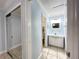 A hallway view of a bathroom with a white vanity and mirrored sliding closet doors at 2316 E Margarita Ct, Kissimmee, FL 34741