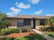 Charming one story villa with well maintained landscaping, brown mulch, and freshly cut grass on a partially cloudy day at 2316 E Margarita Ct, Kissimmee, FL 34741