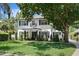 Beautiful two-story home featuring a manicured lawn and charming front porch with black shutters at 2339 Lafayette Ave, Winter Park, FL 32789