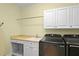 Laundry room featuring modern washer and dryer units, white cabinets, and ample counter space at 2339 Lafayette Ave, Winter Park, FL 32789
