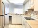 Functional kitchen with white cabinets, tile countertops, and stainless-steel appliances at 2468 Citrus Club Ln # 502, Orlando, FL 32839