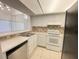 Efficient kitchen featuring white cabinets, tile countertops, and stainless-steel sink at 2468 Citrus Club Ln # 502, Orlando, FL 32839