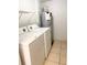 Laundry room featuring a white washer and dryer, water heater, and tiled flooring at 2468 Citrus Club Ln # 502, Orlando, FL 32839