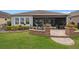 Screened lanai looks out to paver patio and manicured lawn at 2554 Stargrass Cir, Clermont, FL 34715