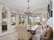 Bright dining area featuring large windows, a modern chandelier, and views of the outdoor area at 2554 Stargrass Cir, Clermont, FL 34715